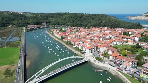 Drohnen-Luftaufnahme in der spanischen ländlichen Kleinstadt mit einer Flussüberquerung und einer weißen Brücke, umgeben