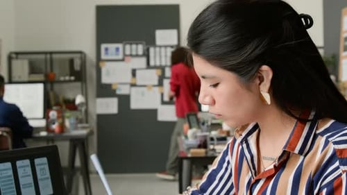 Woman Designs App Interface in Creative Office