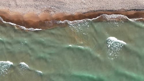 Aerial Top View Waves and Sandy Beach Aerial A Closeup Aerial View of Gentle Waves Rolling Onto a