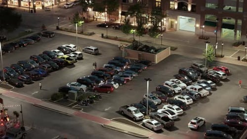 Luftaufnahme eines Nachtparkplatzes mit Autos und Menschen