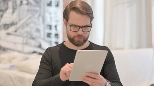 Man Uses Silver Tablet Device Indoors