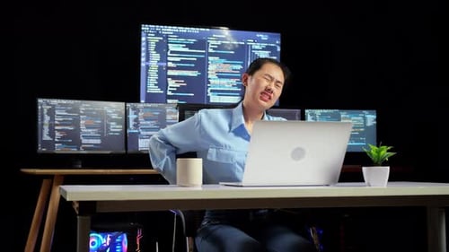 Asian Female Programmer Having A Backache While Writing Code By A Laptop Using Multiple Monitors