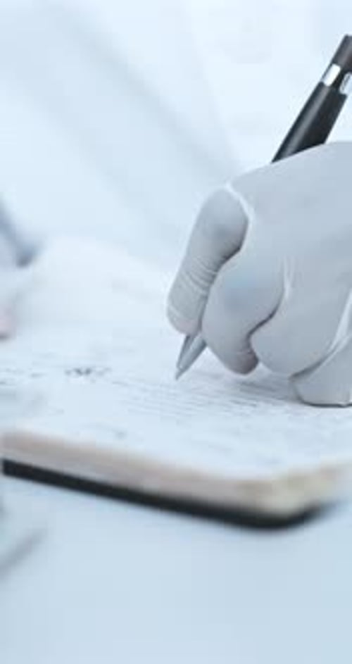 Hand in Glove Writing in Notebook