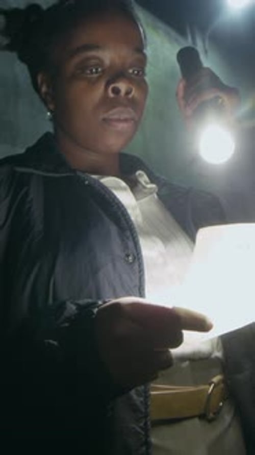 Vertical of Female Police Officer Reading Ransom Note from Criminals