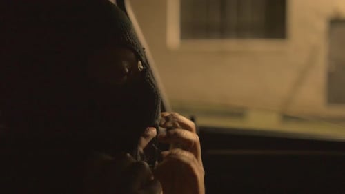 Man in Balaclava Waiting in Car at Night