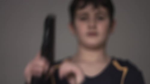 Child Aims Handgun Directly at Camera