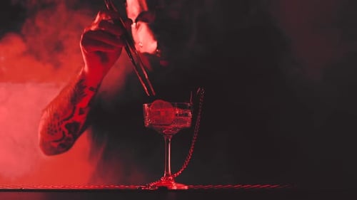 Bartender in Mask Prepares a Cocktail at the Bar