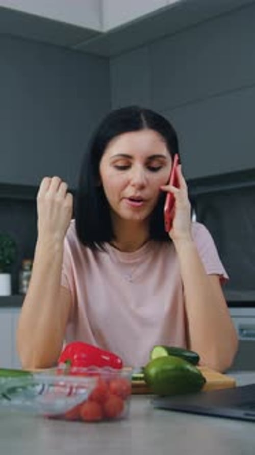 Woman Talking on Phone and Eating Vegetables