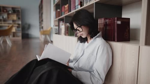 Young asian student reading book in university library