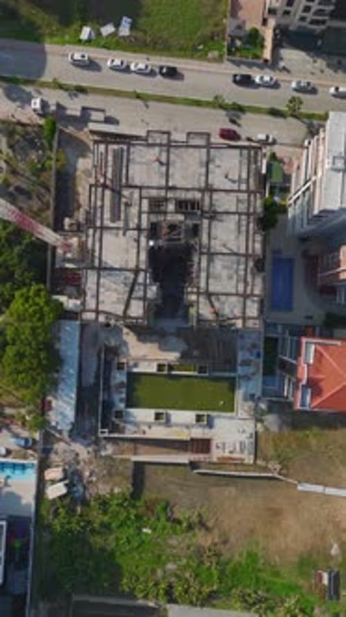 Los ingenieros de vídeo vertical supervisan a los trabajadores que construyen paredes y utilizan mezcladoras de concreto y metal