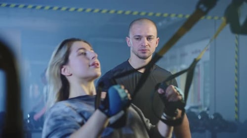 The Girl Performs Trx Exercises in the Gym