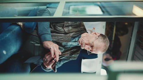 Gros plan d'un homme âgé utilise un téléphone portable lors d'un voyage en train coupé