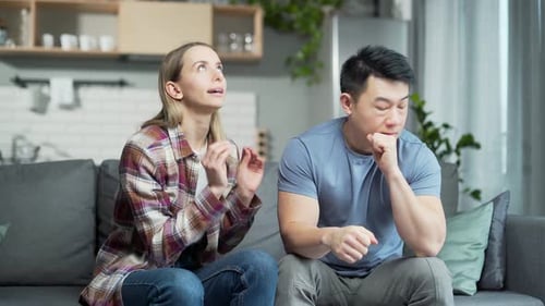 Upset Couple Arguing on Couch at Home