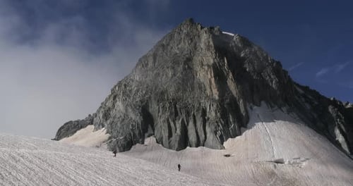 Two mountaineers walking on a glacier in the Alps