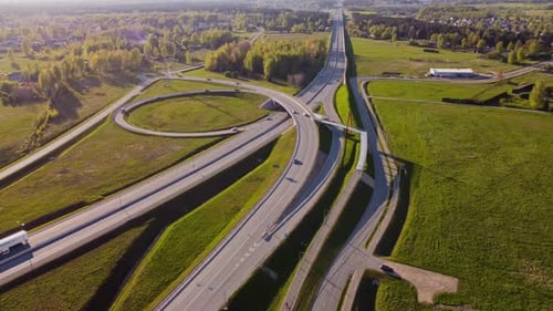 Sunny aerial view of highway overpass and roundabout connecting roads near residential Katlakalns