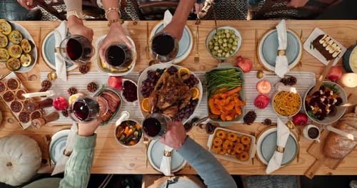 People Toasting Wine Over Festive Thanksgiving Dinner Table