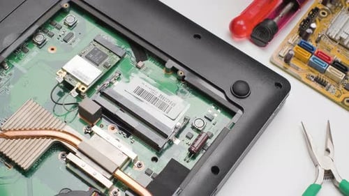 Topdown view person unscrewing and disconnect cables from Wireless card, Laptop repair