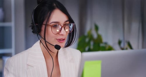 Smiling Woman with Headset Talking to Computer