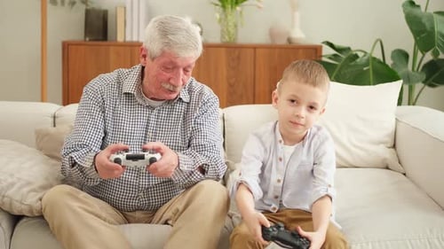 Grandfather and Grandson Playing Video Games at Home