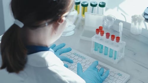 Female Scientist Typing at Her Desk in Lab