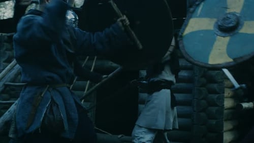 Large-Scale Medieval Battle Reenactment. Violent Tribe of Warriors Run Through The Gates of the Woo