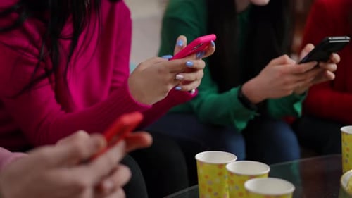 Friends Using Phones Together at a Table