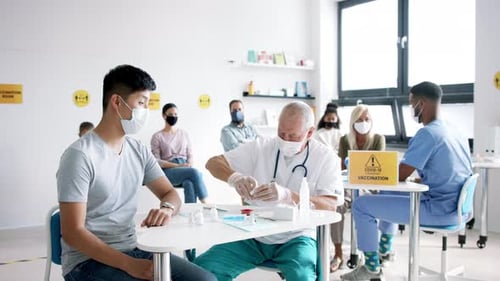 Doctor giving patient injection at vaccination site