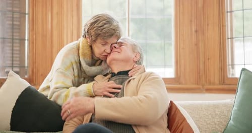 Senior Couple Embracing Affectionately on Couch