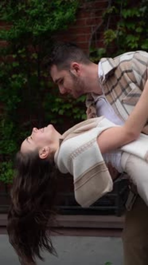 Romantic Moment Couple Dancing on Sidewalk Near IvyCovered Building