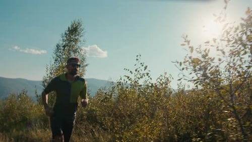 Adult Male Runs on Sunny Mountain Trail