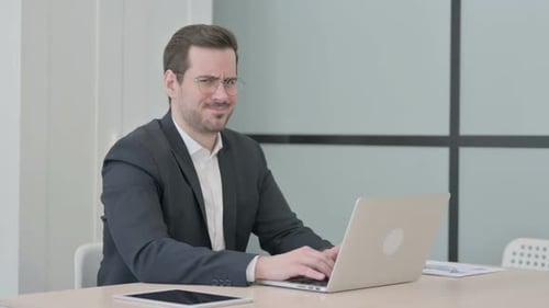 Office Worker Displeased Expression Typing on Laptop