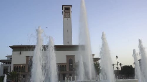 Fontain water jet in action at Casablanca's new Mohammed 5 Square, Wilaya city hall with its clock t
