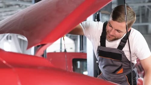 Ein professioneller Automechaniker untersucht ein Auto in einer Autowerkstatt und führt eine Reihe von Tests durch