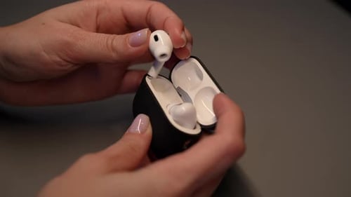 Woman Removing Wireless Earbuds from Charging Case