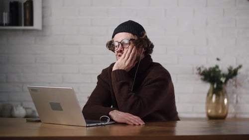 A Young Bored Man Listening Lecture Via Laptop Unmotivated Employee Feel Sleepy During Daily Meet