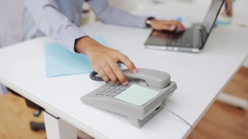 Conceito de negócios, pessoas e trabalho - empresário discando manualmente o número de telefone no escritório