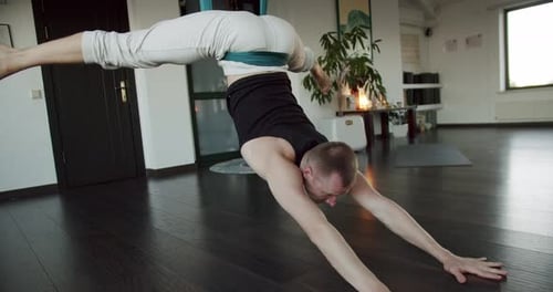Man Practices Aerial Yoga with Fabric Sling