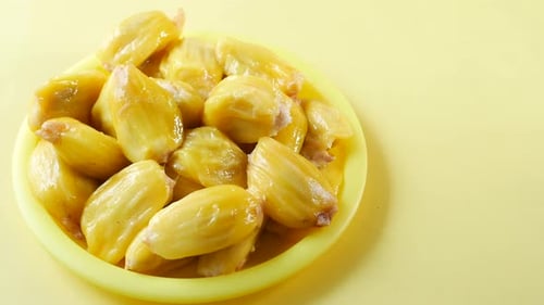 Top View of Slice of Jackfruits in Plate on Yellow Background