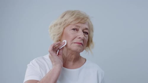 Beautiful Senior Model Cleaning Her Face for Posing in the Photo Studio Portrait of Lovely Blonde