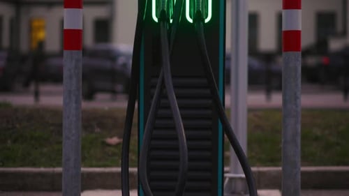 An Electric Car is Charging at a Station in the City