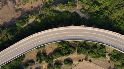 Aerial in Tarifa, cars driving a curved highway road.