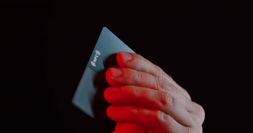 Hand Holding NFC Card Under Red Light
