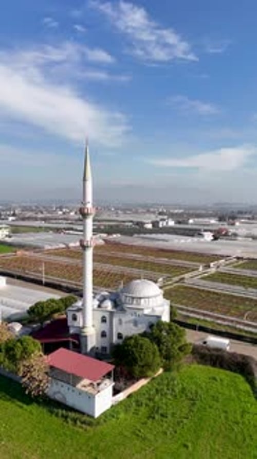 Vue aérienne verticale de la mosquée et des champs agricoles avec la ville en arrière-plan