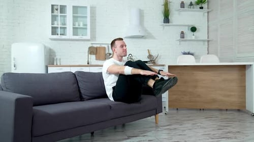 Man Exercising on Couch in Modern Home