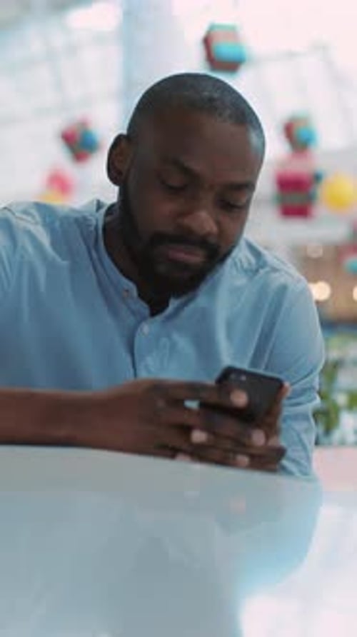 Smiling Man Using Smartphone Indoors