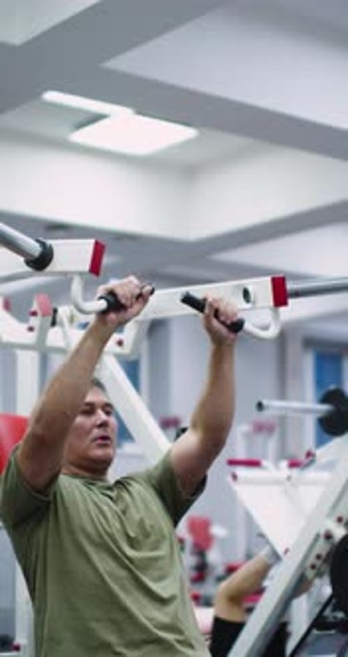 Man Exercising at Gym on Weight Machine