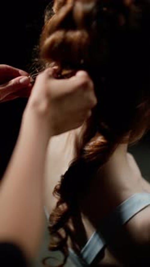 Hands Styling a Woman's Hair From the Back Highlighting the Intricate Hair Design and Texture with