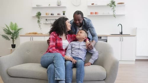 Happy Family Smiling on Couch in Living Room