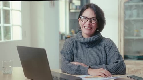 Joyous Mature Woman with Laptop at Home