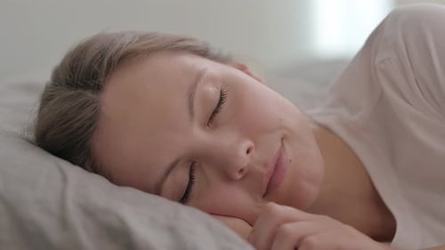 Young Woman Sleeping Peacefully in Bed at Home
